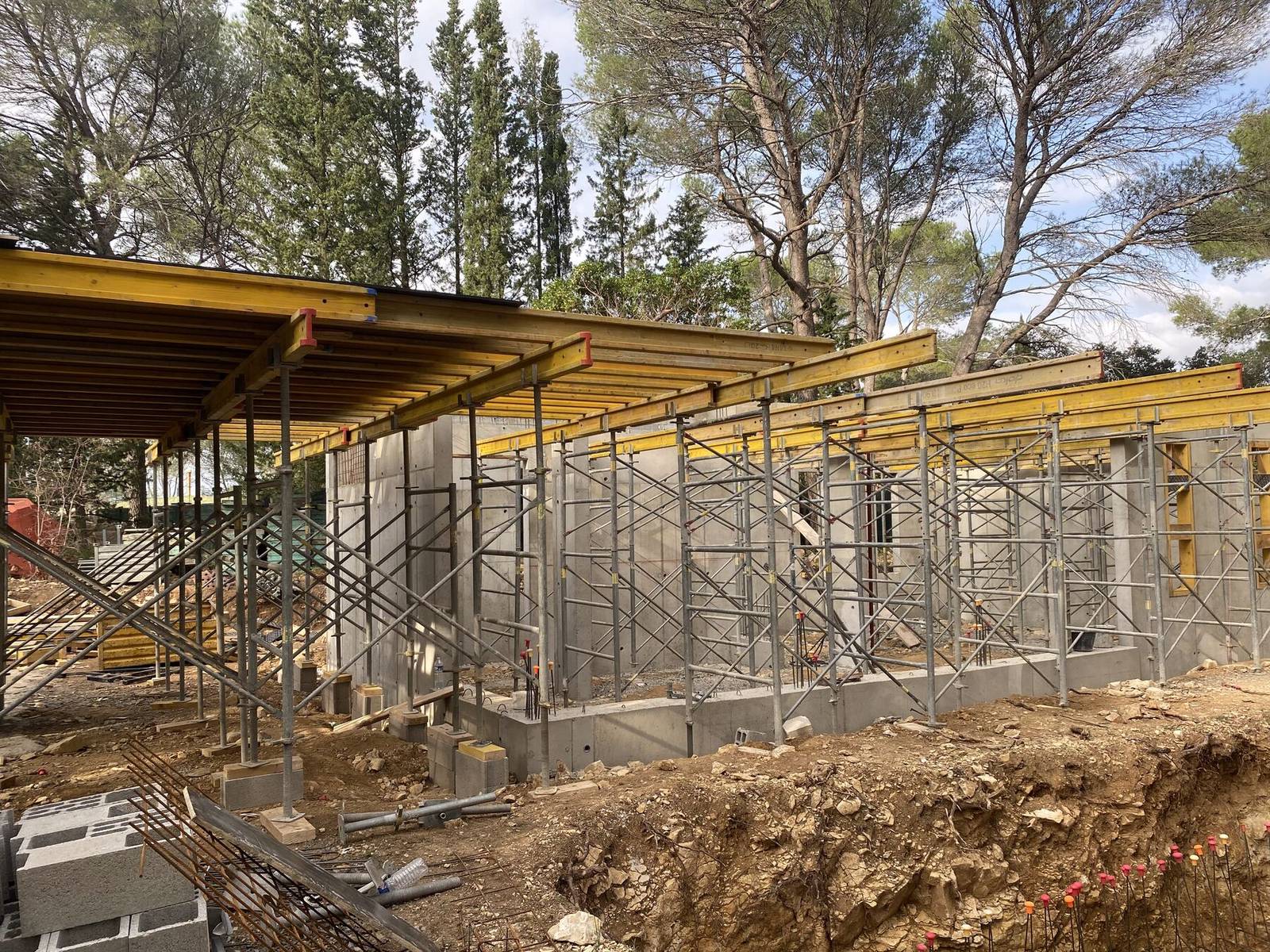 Chantier AKTUG CONSTRUCTION : voiles en béton banché et coffrage de plancher sous les pins
